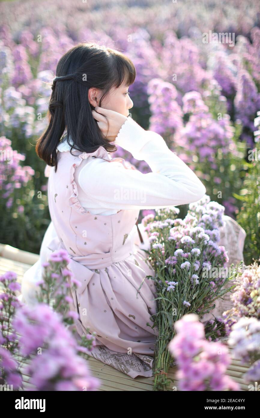 Portrait de fille asiatique avec fond de fleurs violettes Banque D'Images