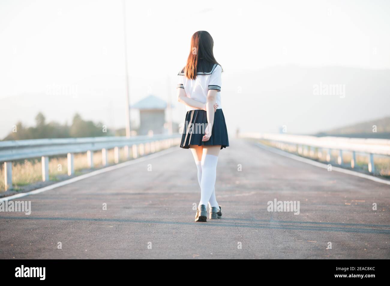 Portrait de fille d'école japonaise uniforme sourire avec passerelle et rivière Banque D'Images