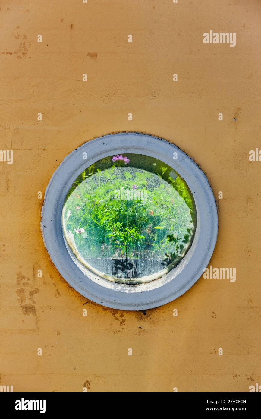 Hublot dans un mur jaune Banque D'Images