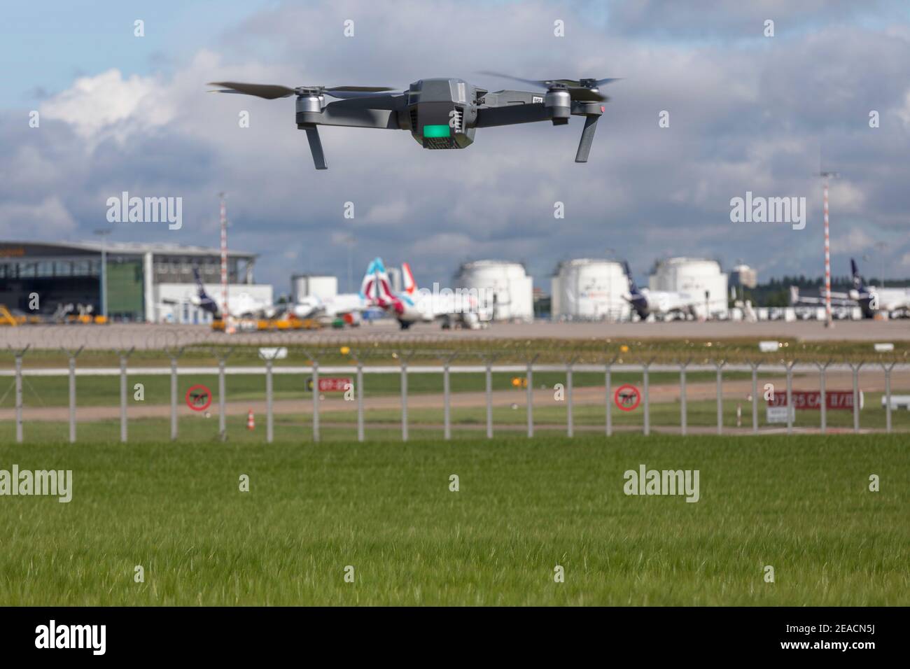 Le quadricoptère de drone s'approche de la zone d'interdiction intérieure des locaux de l'aéroport, de la piste, des réservoirs de kérosène, de l'avion Banque D'Images