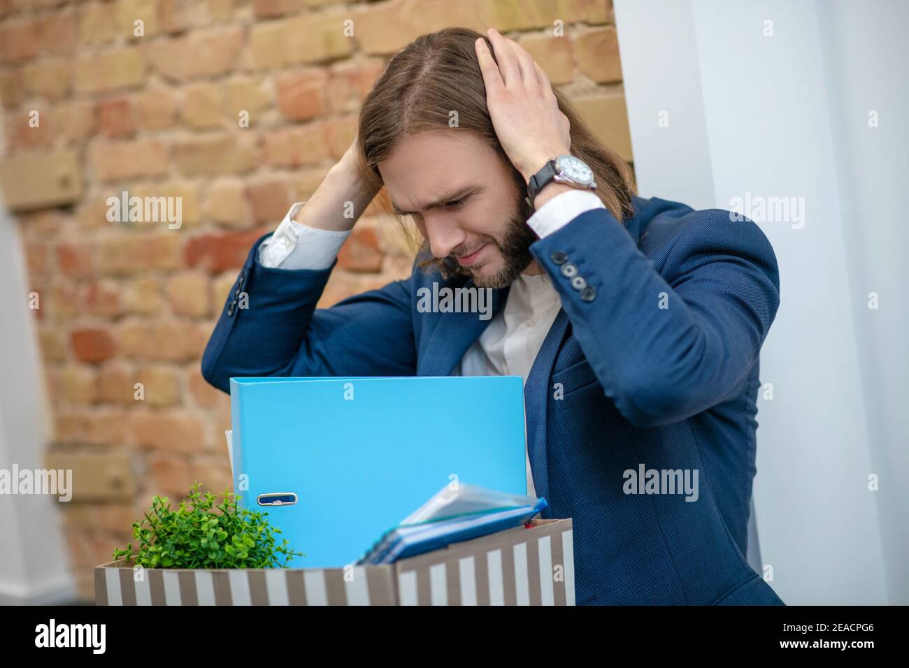Homme émotionnel tenant la tête avec ses mains Banque D'Images
