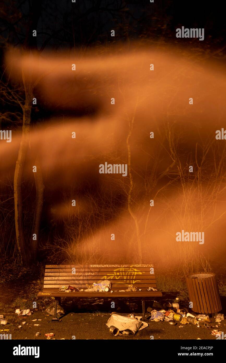 Banc de parc avec des ordures, main fantôme, nuage, brume Banque D'Images