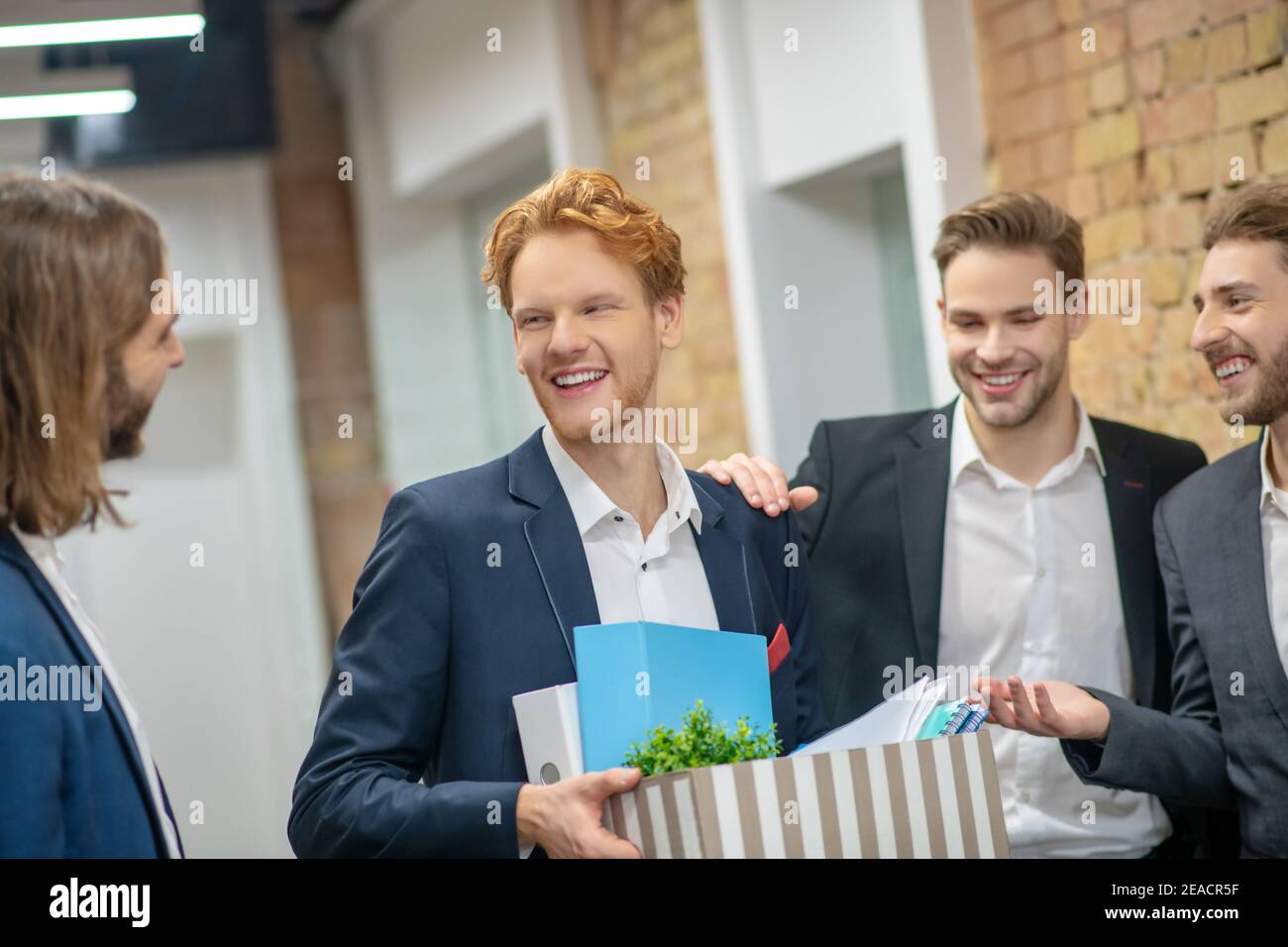 Des collègues masculins joyeux communiquent dans le couloir Banque D'Images