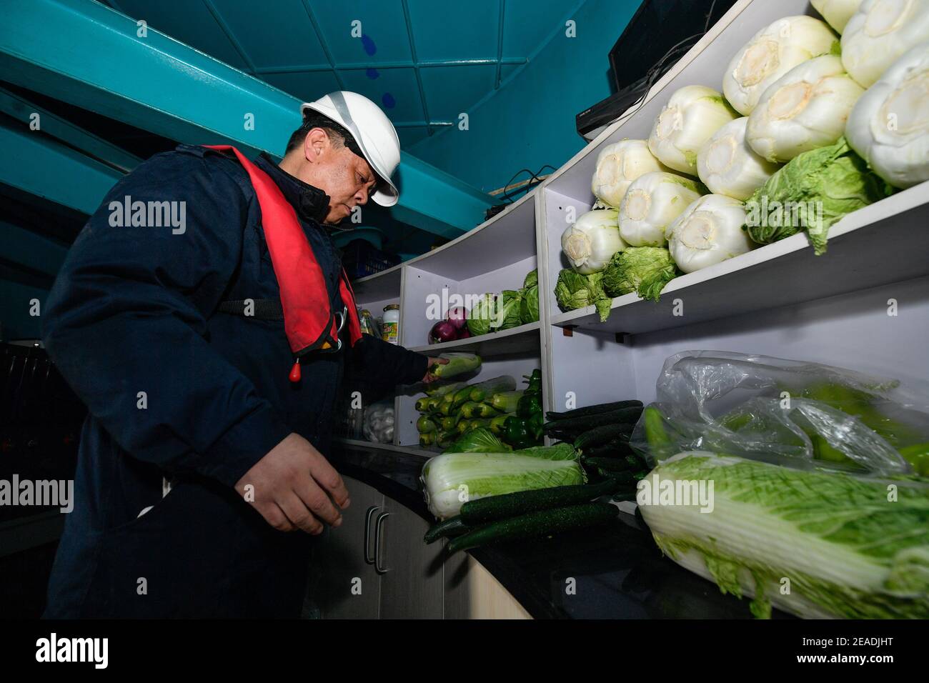 (210209) -- TIANJIN, le 9 février 2021 (Xinhua) -- Li Hongqi prépare le déjeuner au phare de Dagu, qui se trouve à 12.9 milles marins à l'est du port de Tianjin, dans la municipalité de Tianjin, au nord de la Chine, le 5 février 2021. Le phare de Dagu, d'une hauteur de 38.3 mètres, avec une portée lumineuse de 17 milles marins, est mis en service depuis le 1er mai 1978. Li Hongqi, 47 ans, est un gardien du phare de Dagu. Les gardiens travaillent ici dans une rotation d'un mois, en maintenant les lumières du phare pour garantir la sécurité de la navigation des navires. Les nécessités quotidiennes sont servies une fois par mois, et les gardiens se tournent vers les dispositifs d'éclairage et de chauffage seulement quand ils sont au besoin Banque D'Images