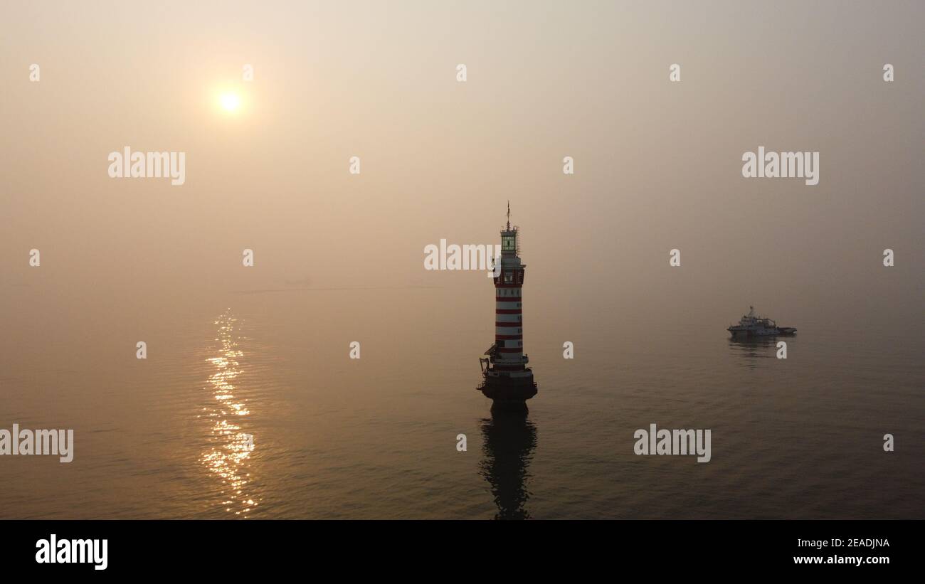 (210209) -- TIANJIN, le 9 février 2021 (Xinhua) -- une photo aérienne prise le 20 janvier 2021 montre le phare de Dagu qui se trouve à 12.9 milles marins à l'est du port de Tianjin de la municipalité de Tianjin, au nord de la Chine. Le phare de Dagu, d'une hauteur de 38.3 mètres, avec une portée lumineuse de 17 milles marins, est mis en service depuis le 1er mai 1978. Li Hongqi, 47 ans, est un gardien du phare de Dagu. Les gardiens travaillent ici dans une rotation d'un mois, en maintenant les lumières du phare pour garantir la sécurité de la navigation des navires. Les nécessités quotidiennes sont servies une fois par mois, et les gardiens se tournent vers les dispositifs d'éclairage et de chauffage seulement quand ils sont au besoin Banque D'Images