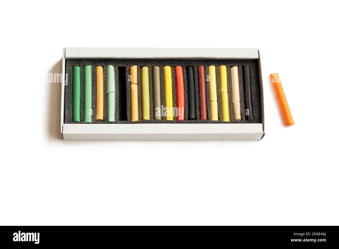 Boîte avec crayons pastel sur fond blanc Banque D'Images