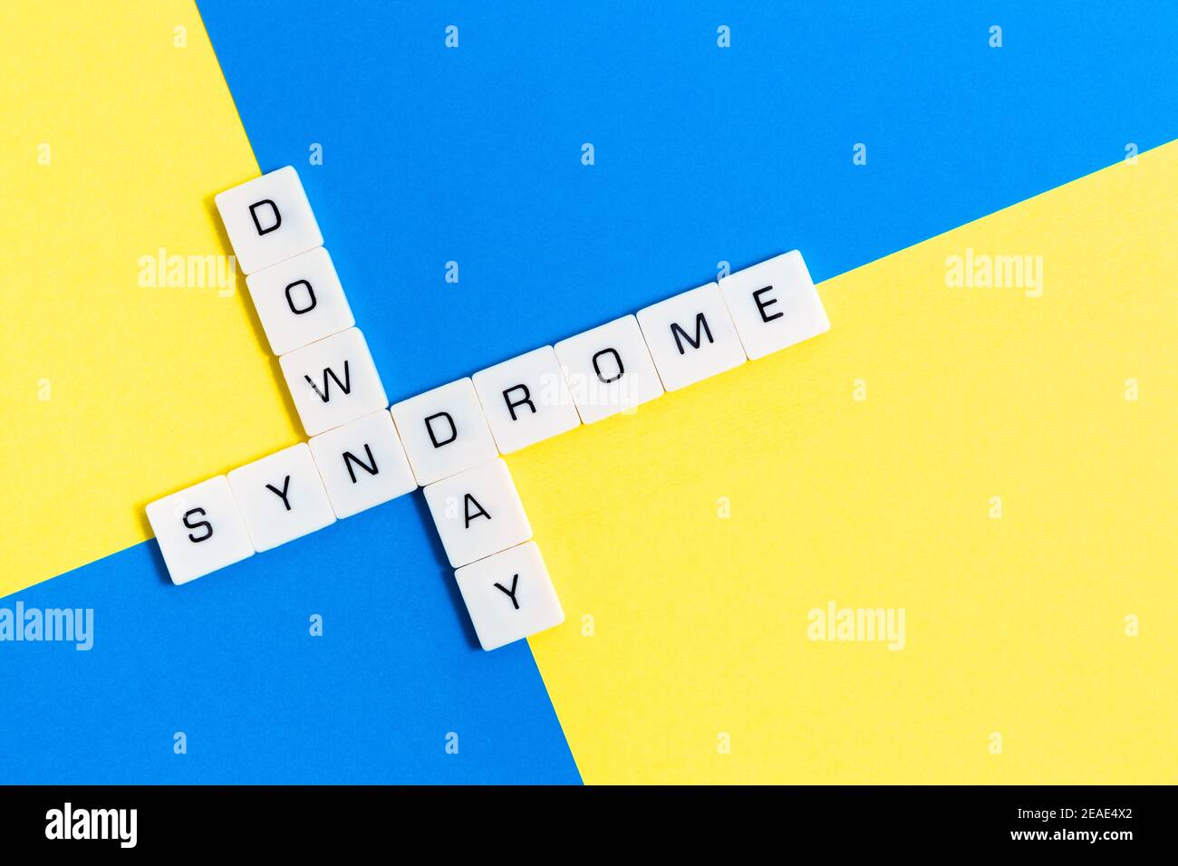 Message « jour du syndrome de Down » avec des mots croisés isolés sur fond jaune et bleu. Banque D'Images