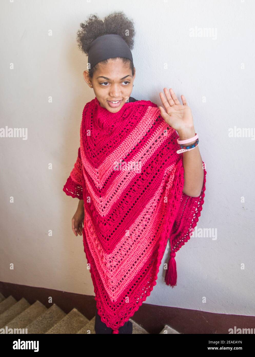 Élégant poncho ou châle rouge et rose attaché par un Jeune modèle brésilien souriant et heureux Banque D'Images Élégant poncho ou châle rouge et rose attaché par un Jeune modèle brésilien souriant et heureux Banque D'Images