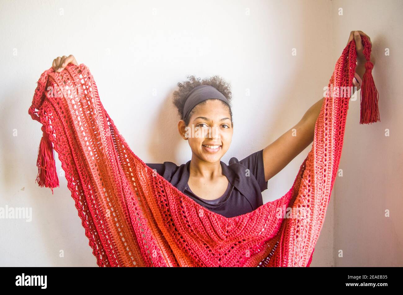 Élégant poncho ou châle rouge et rose attaché par un Jeune modèle brésilien souriant et heureux Banque D'Images Élégant poncho ou châle rouge et rose attaché par un Jeune modèle brésilien souriant et heureux Banque D'Images