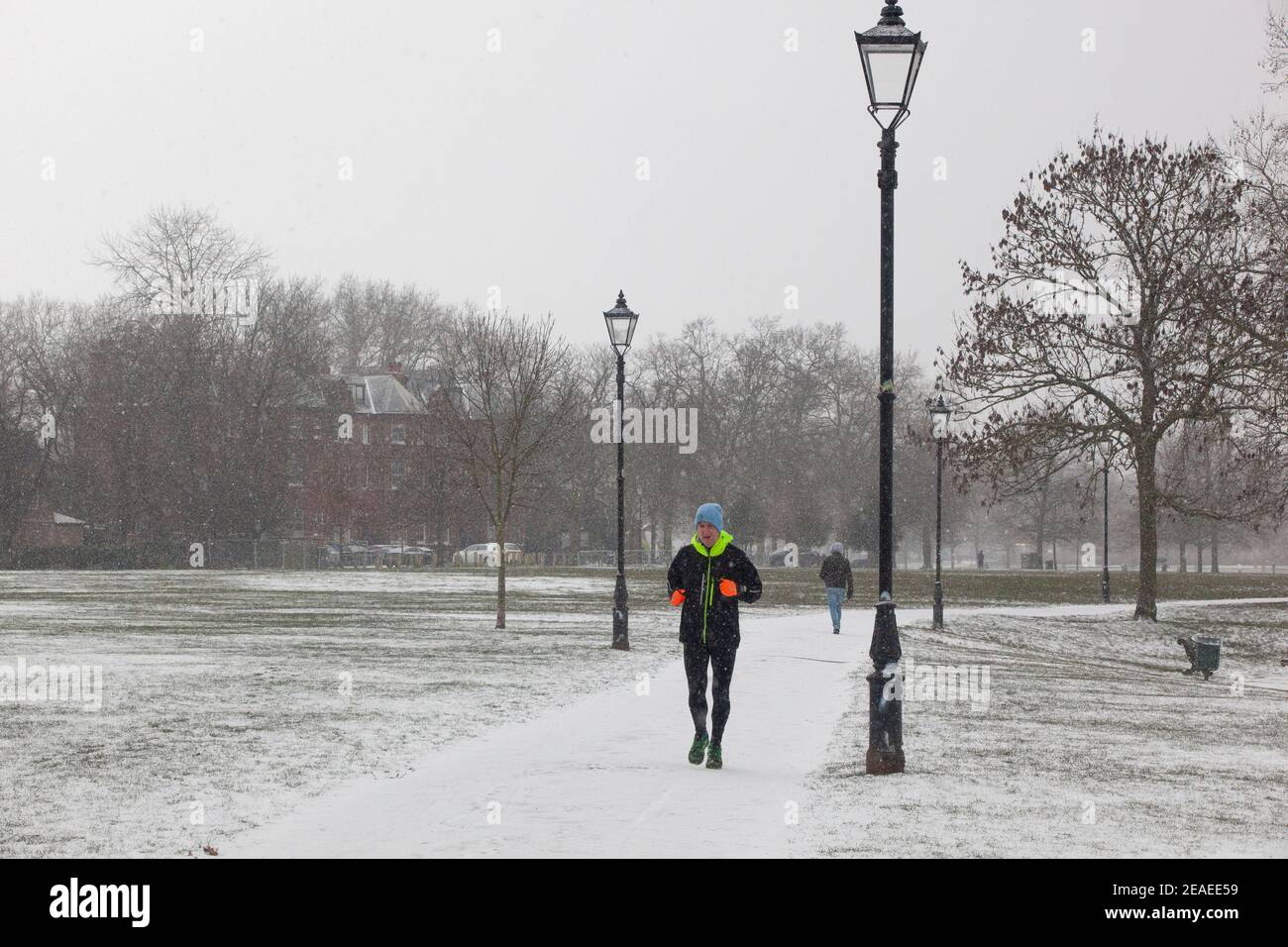 Londres, Royaume-Uni. 9 février 2021: Après trois jours de neige à Londres, il commence à s'établir et les vents ont chuté au fur et à mesure que la tempête Darcy est passée. Sur Clapham Common quelques personnes prennent l'exercice et les bus de passage portent des messages sur le port de couvertures de visage. Anna Watson/Alay Live News Banque D'Images