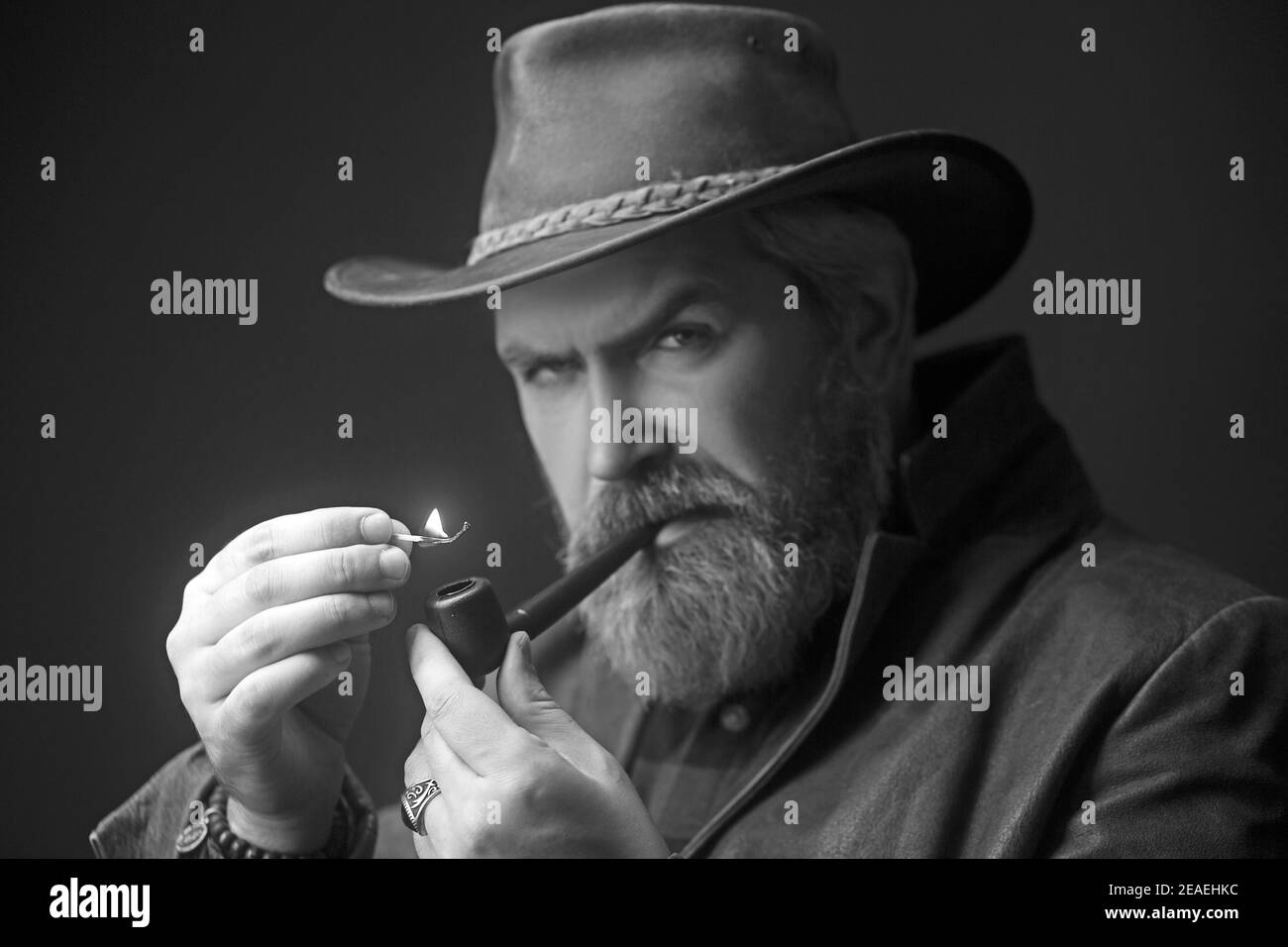 Homme barbu fumant pipe de tradition. Portrait de mode. Banque D'Images