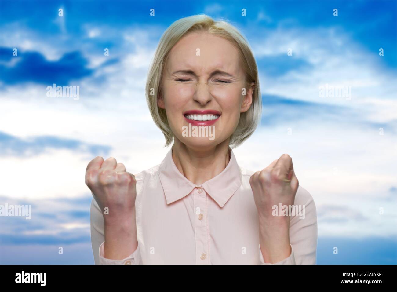 Une femme d'affaires heureuse en blouse blanche se réjouit. Banque D'Images