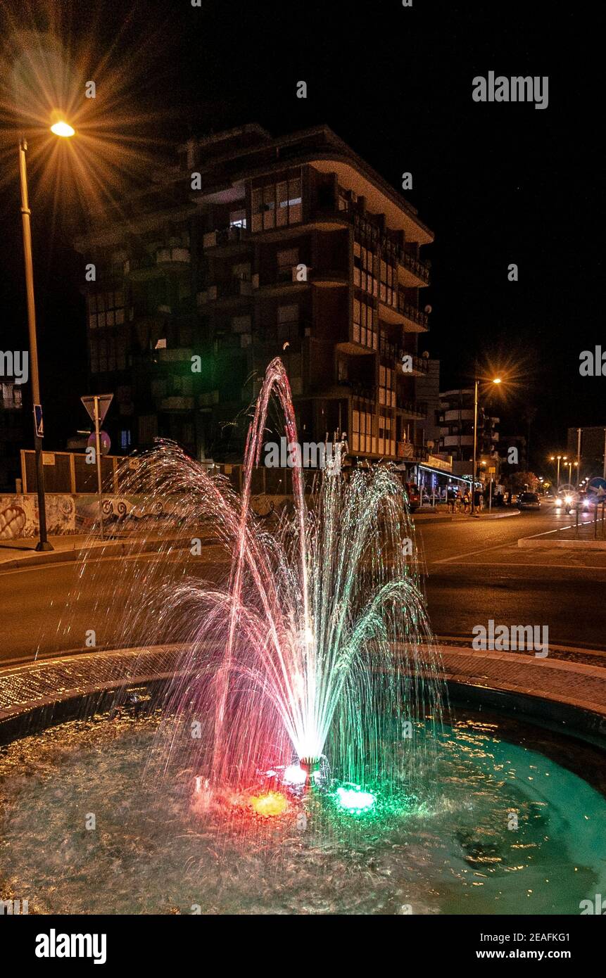 Fontaine tricolore italienne illuminée dans un centre urbain Banque D'Images