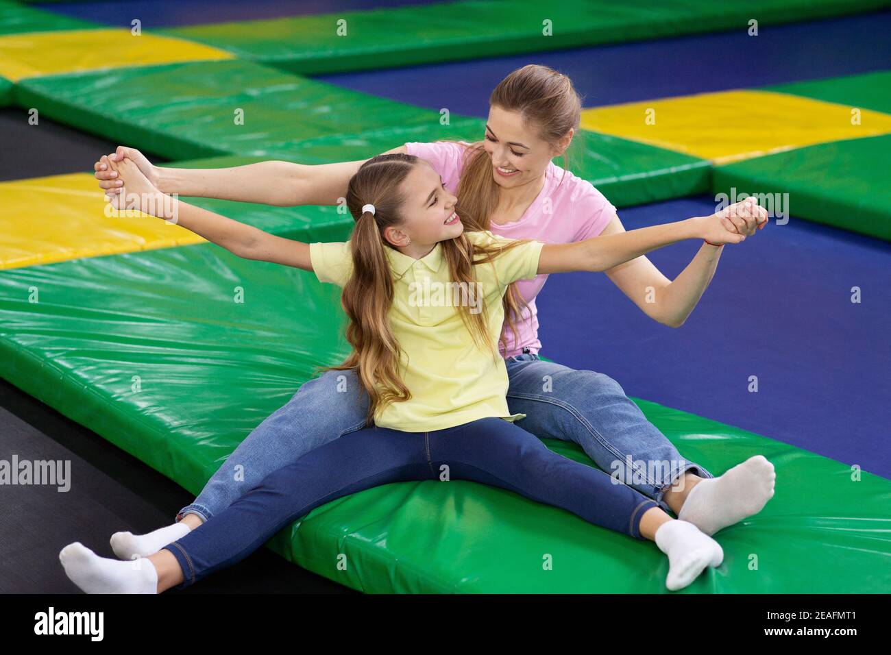 Adorable jeune fille avec sa maman joyeuse qui se berce dans le parc du  trampoline. Passe-temps et loisirs amusants Photo Stock - Alamy