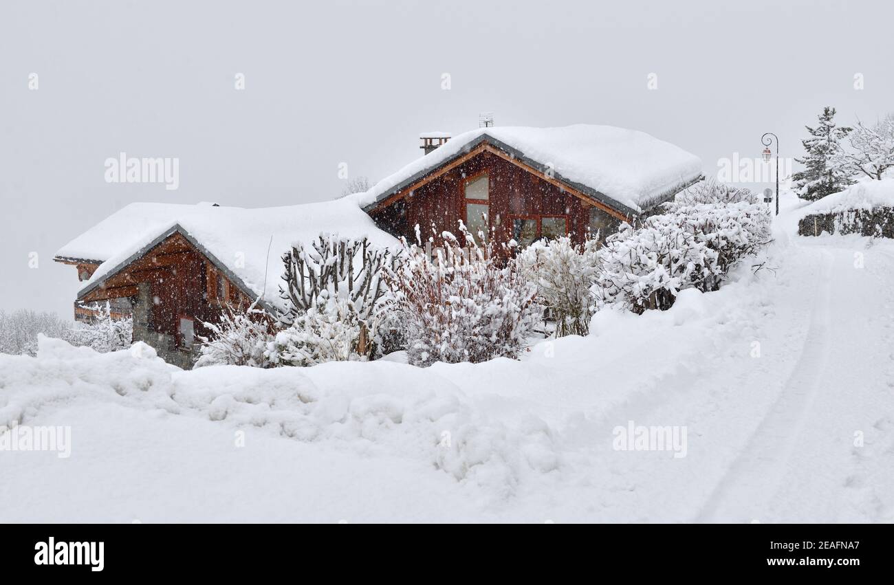 maisons en bois couvertes de neige dans le village alpin de montagne sous chute de neige Banque D'Images