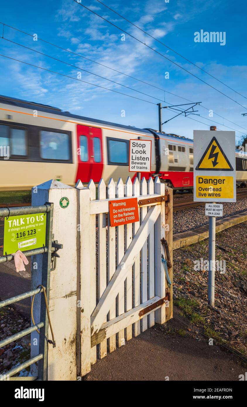 Passage du train piéton porte avec passage du train Greater Anglia - passage de niveau non automatisé pour piétons avec panneaux d'avertissement. Banque D'Images