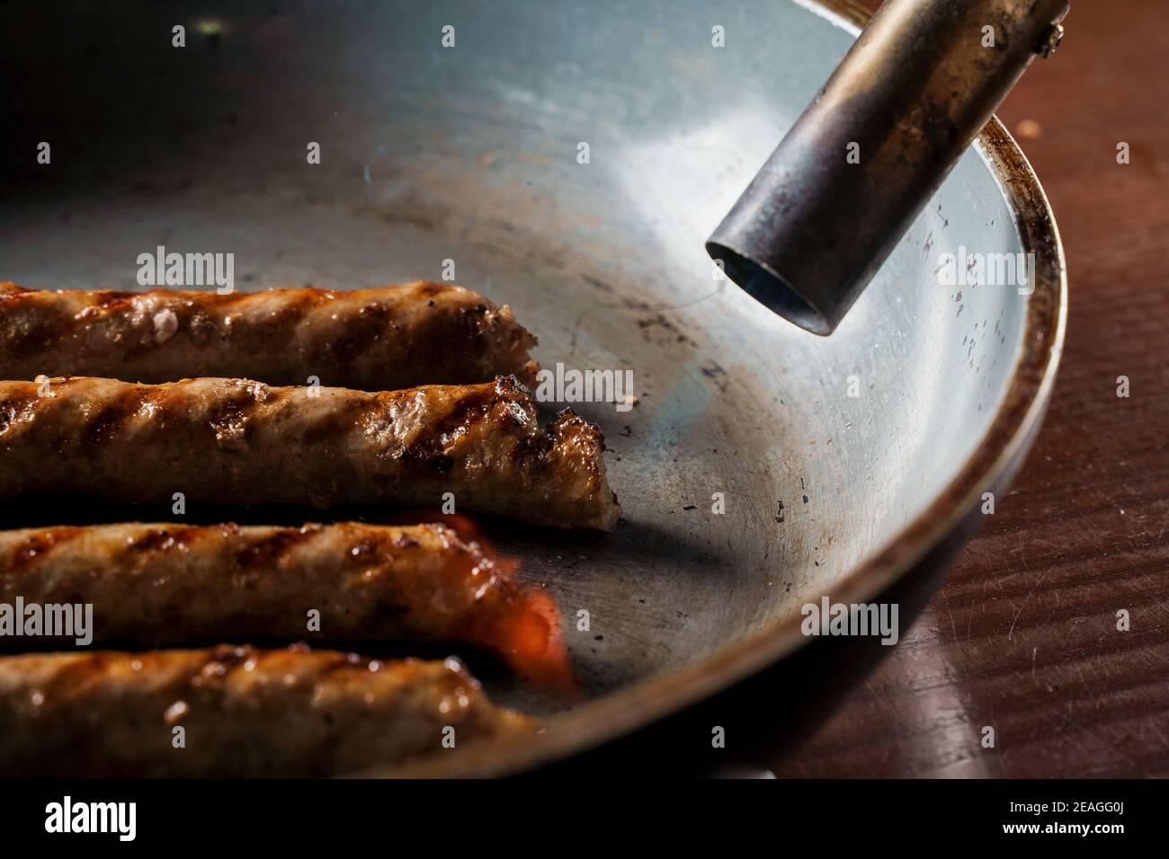 Saucisses grillées et légumes aux herbes dans une poêle en fer | Photo