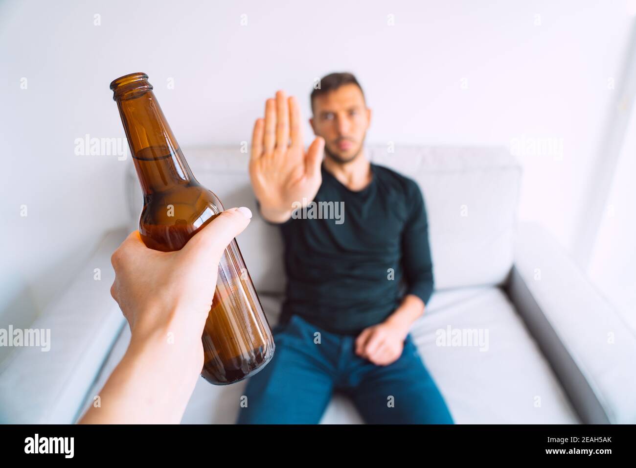 Pas d'alcool. Le jeune homme refuse de boire de la bière, faisant un geste d'arrêt à la bouteille de bière Banque D'Images