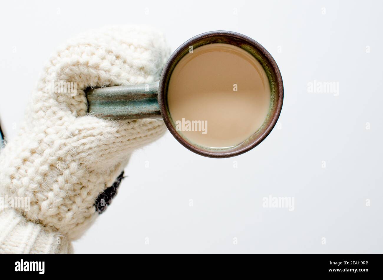 Moufles en laine chaude, gant tenant une tasse de café vert avec mil pour  un style de vie hivernal. Tasse en céramique blanche avec liquide brun  Photo Stock - Alamy
