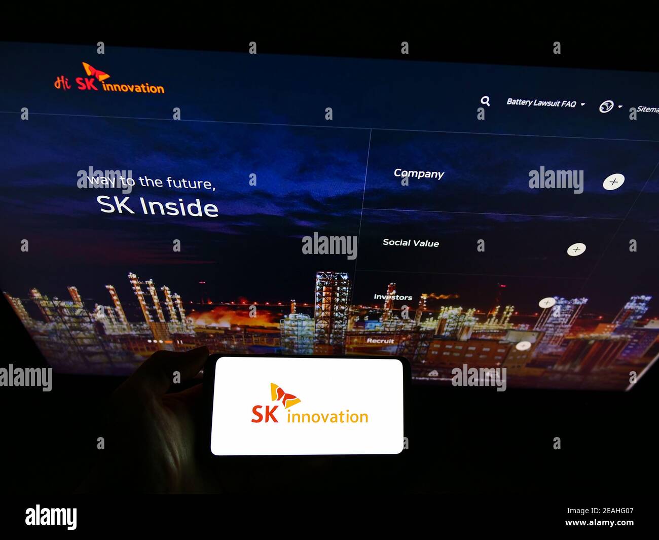 Personne tenant un smartphone avec le logo de la société sud-coréenne de pétrole et de gaz SK innovation à l'écran devant le site Web. Mise au point sur l'affichage du téléphone. Banque D'Images