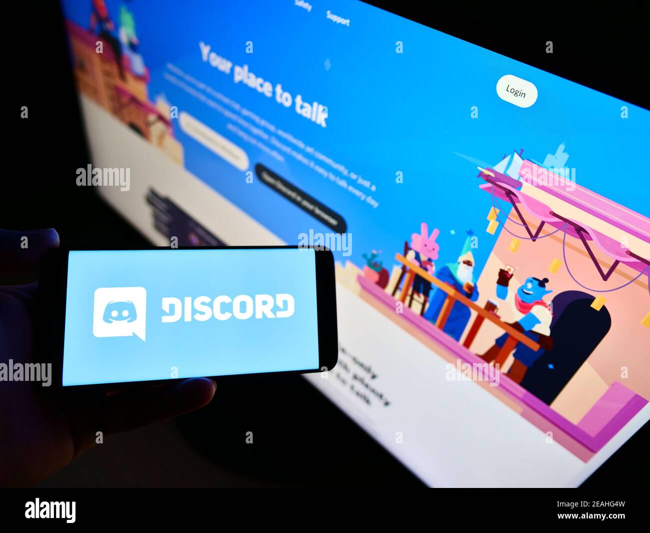 Personne tenant un téléphone mobile avec le logo de la plate-forme de communication américaine développé par discord Inc. À l'écran en face de la page Web. Mise au point sur l'affichage du téléphone. Banque D'Images