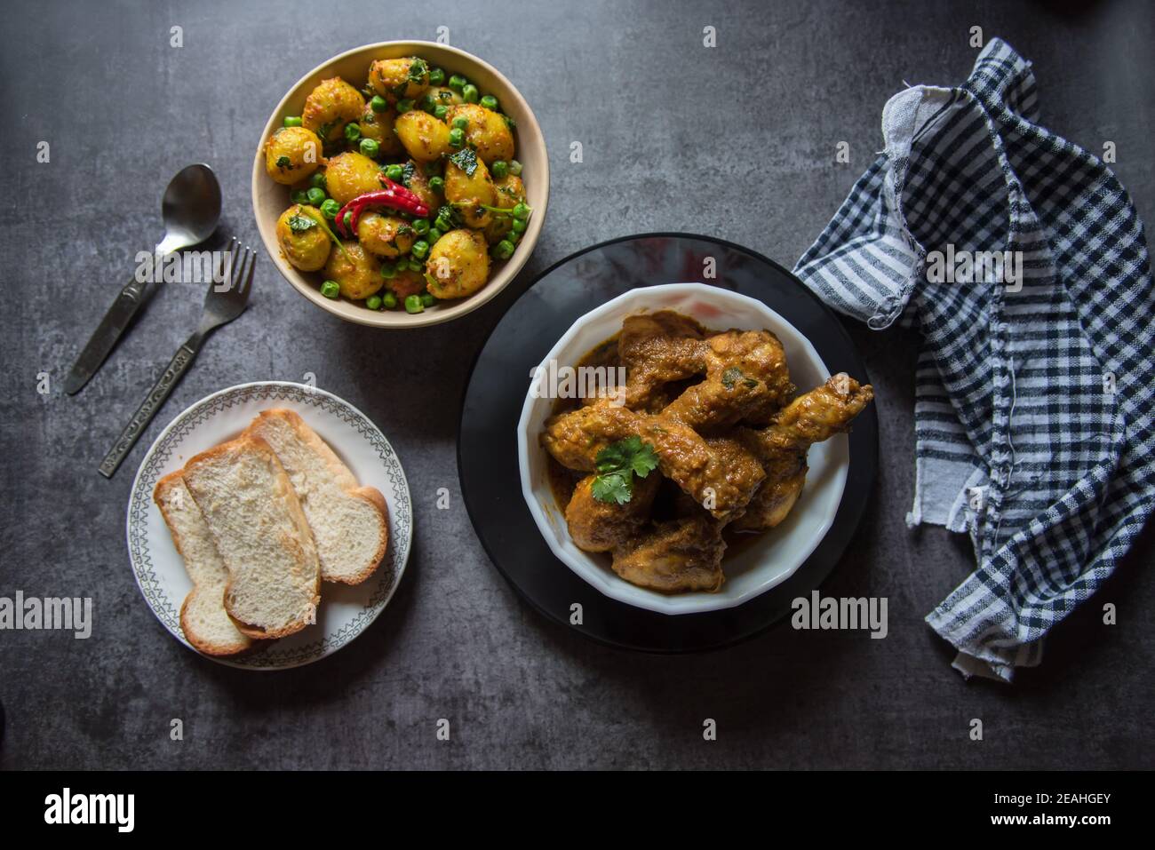 Repas indien complet de poulet en sauce, rade de de dum ou de pommes de terre vapeur et de pain sur un fond. Vue de dessus, mise au point sélective. Banque D'Images