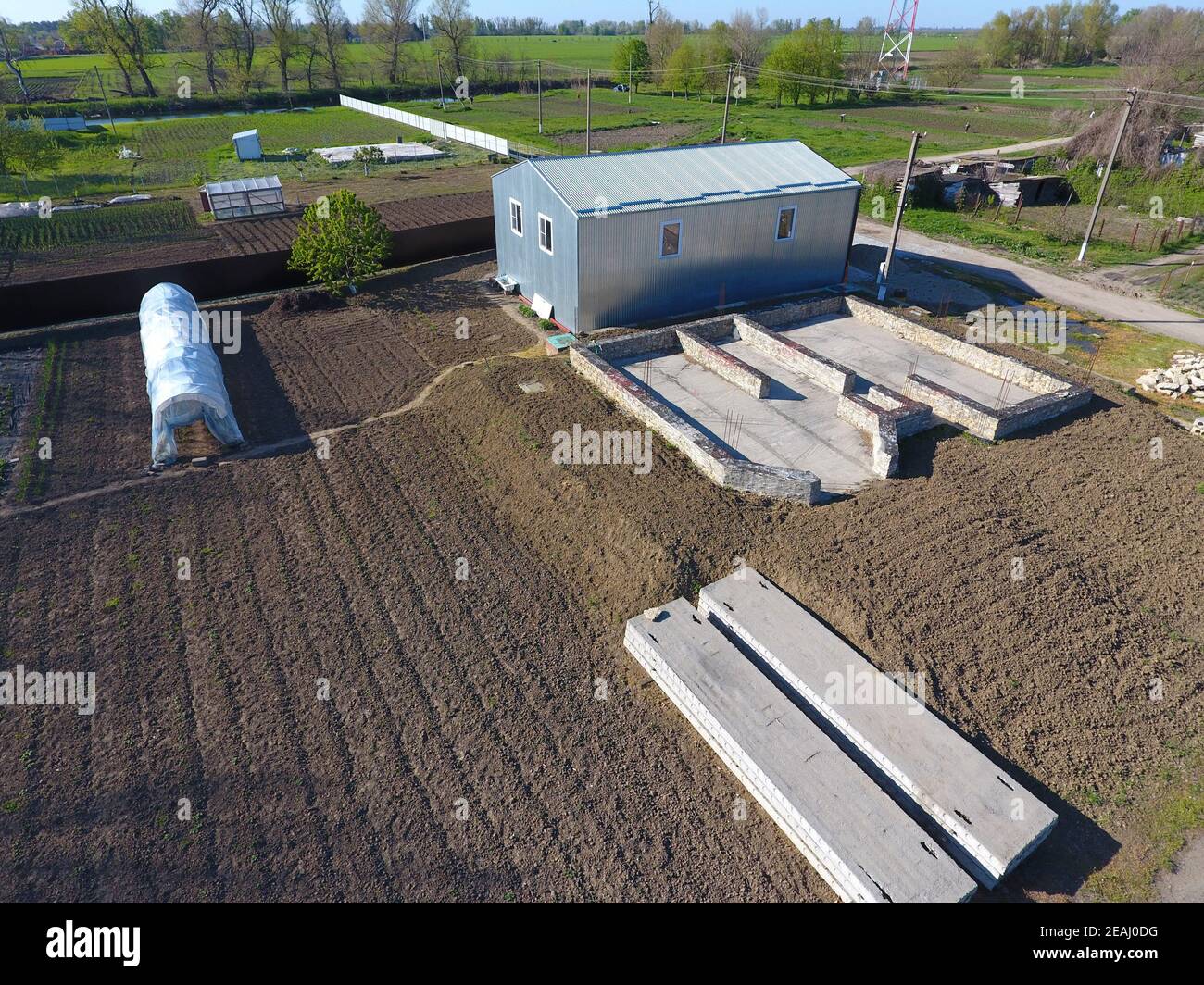 Bâtiments sur le site. Hangar de métal ondulé, de profil. La fondation de la maison. Banque D'Images