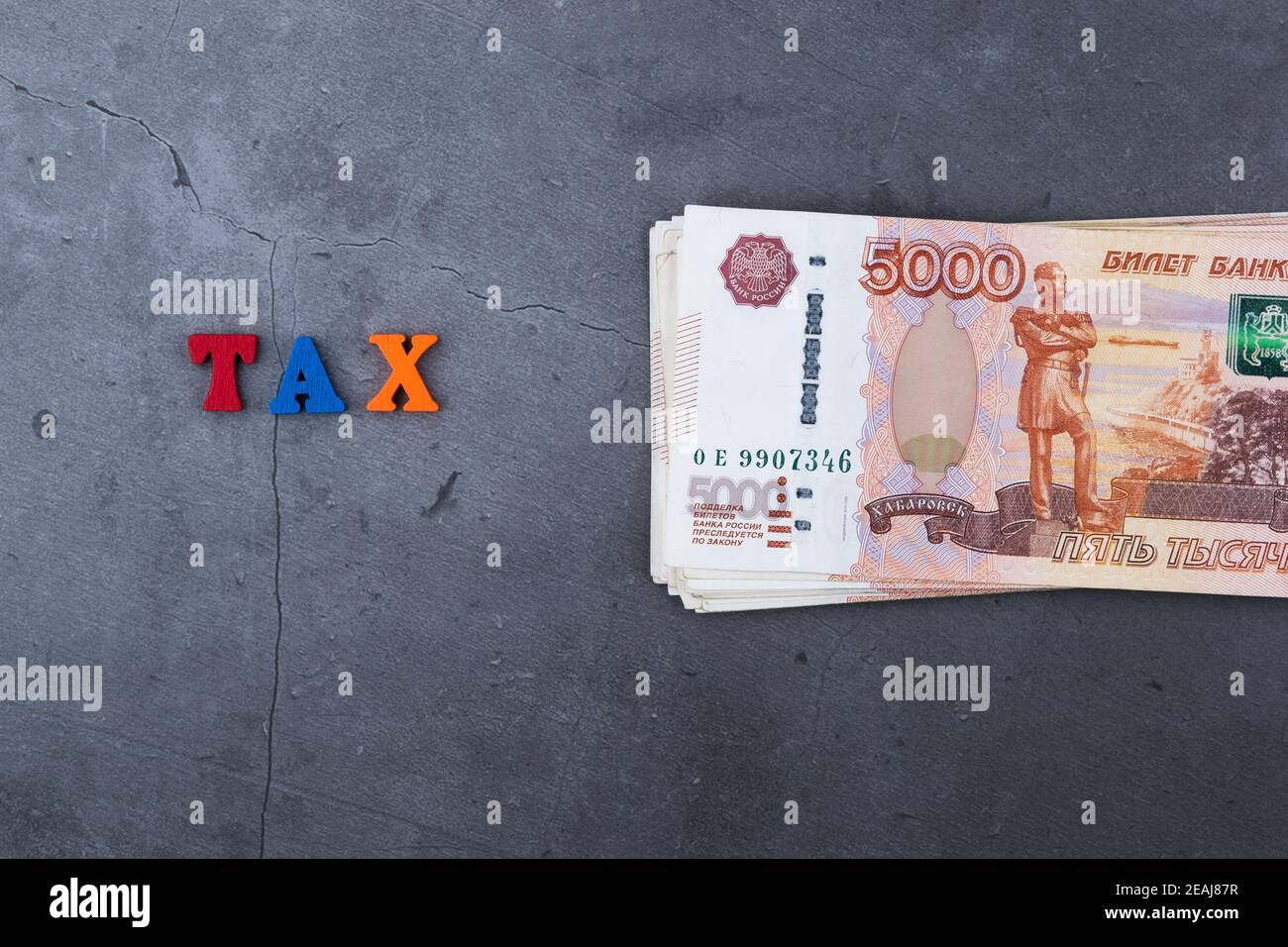 Grande pile de billets de banque russes de cinq mille roubles sur fond de ciment gris. Banque D'Images