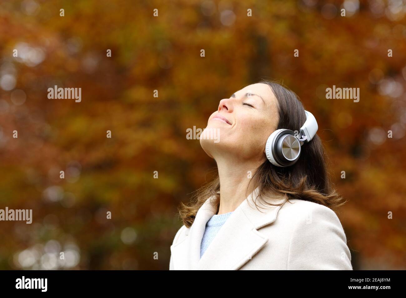 Femme d'âge moyen respirant de l'air frais avec un casque en automne Banque D'Images