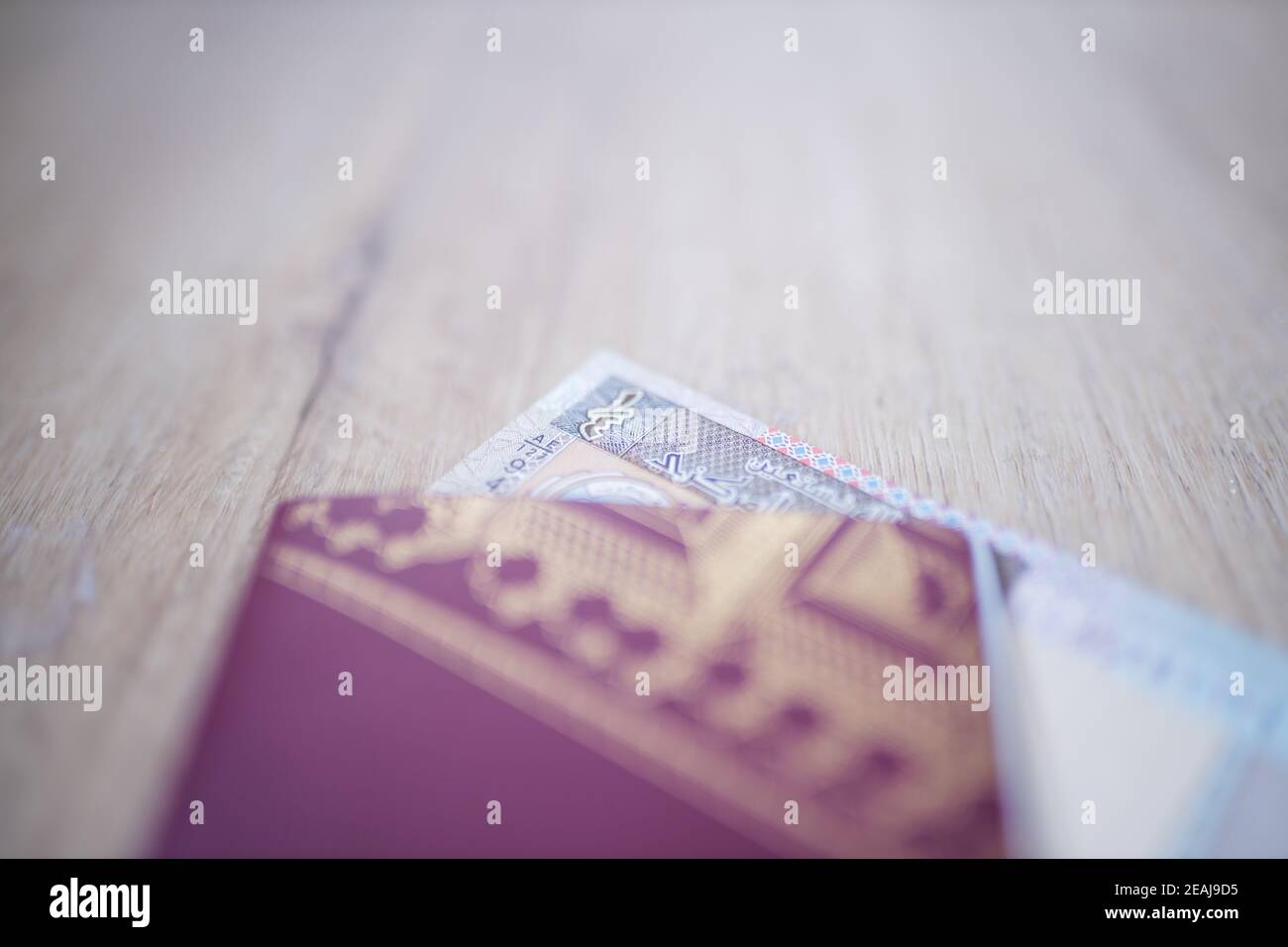 Koweit Quarter Dinar partiellement à l'intérieur d'un passeport de Suède flou Banque D'Images