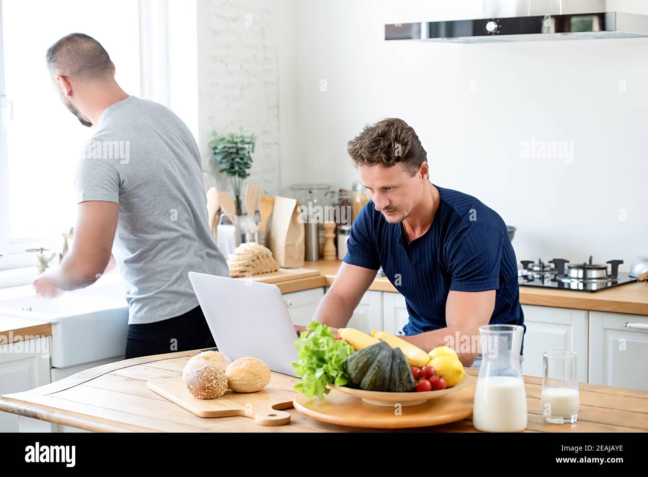 Un jeune couple gay passe le matin ensemble dans sa cuisine à la maison Banque D'Images