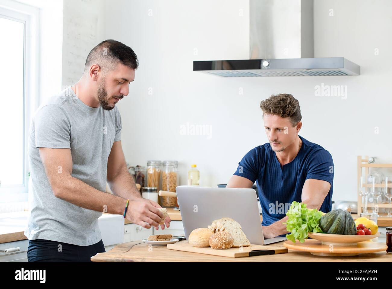 Un jeune couple gay passe le matin ensemble dans sa cuisine à la maison pour le concept de style de vie lgbt Banque D'Images