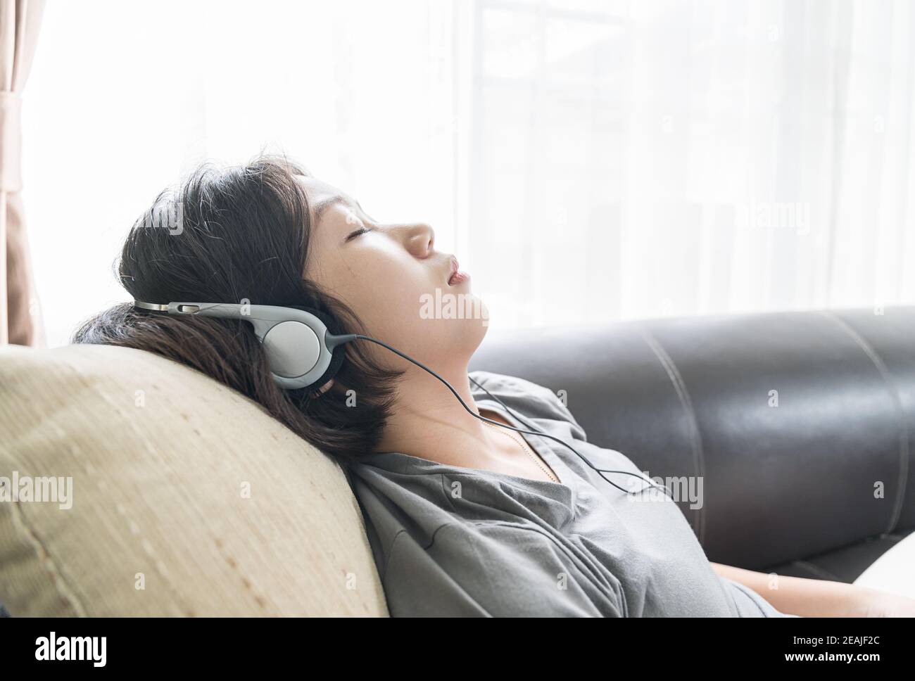 Young Asian woman cheveux courts listening music Banque D'Images