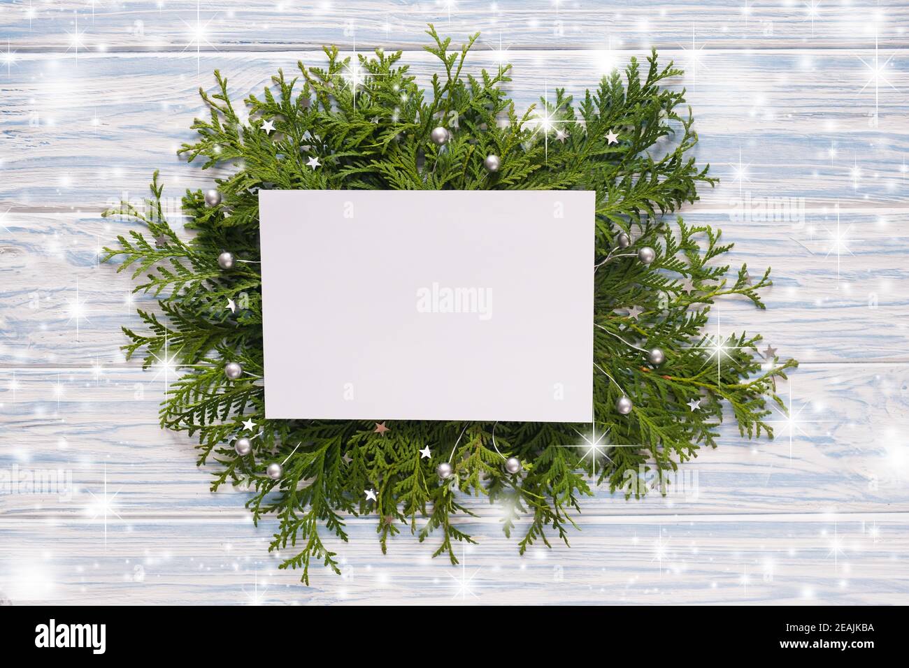 Mockup carte de Noël et branches de sapin sur fond bleu en bois. Banque D'Images