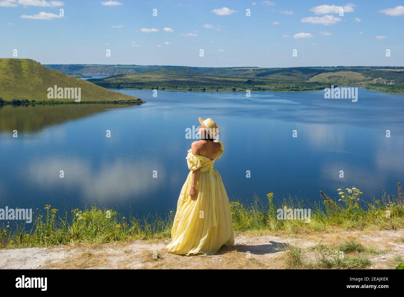 Une fille dans une longue robe debout sur une falaise par la baie Photo  Stock - Alamy