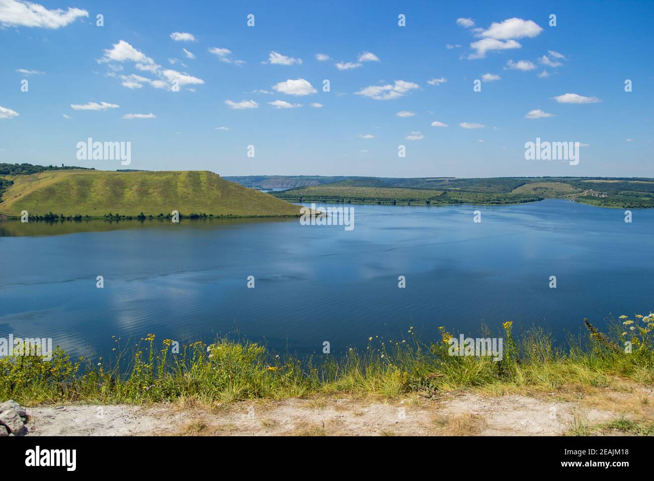 Belle vue panoramique sur un grand lac parmi les collines par temps ensoleillé Banque D'Images