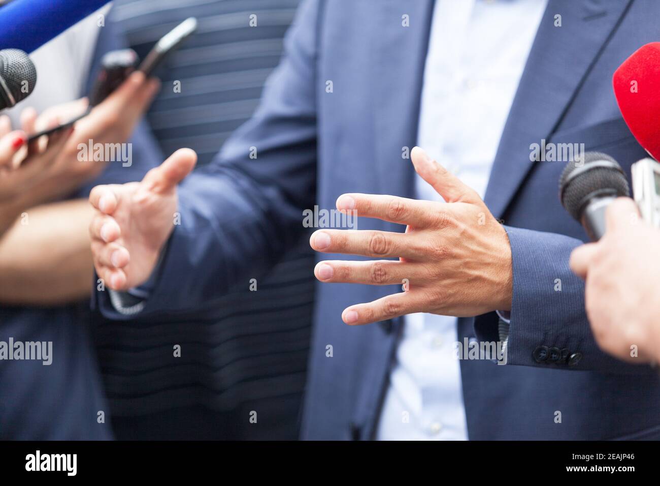 Homme d'affaires ou homme politique qui fait des gestes lors d'une conférence de presse Banque D'Images