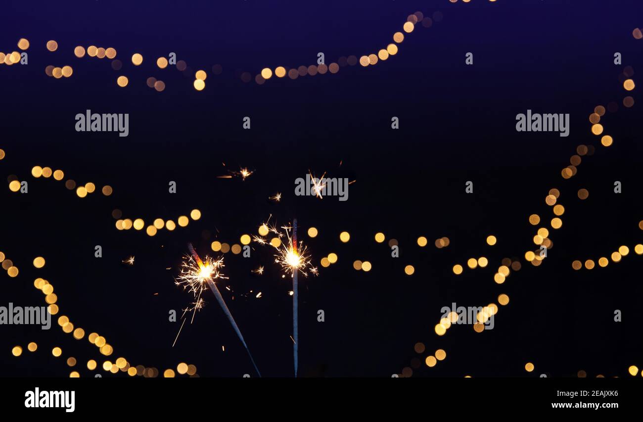Sparkler brûlant avec fond de bokeh festif pour le nouvel an et le concept de Noël, espace pour le texte Banque D'Images