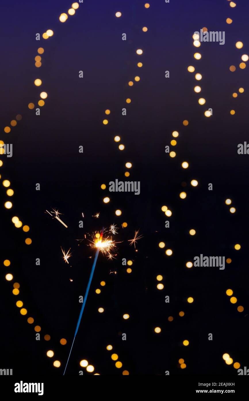 Sparkler brûlant avec fond de bokeh festif pour le nouvel an et le concept de Noël, espace pour le texte Banque D'Images
