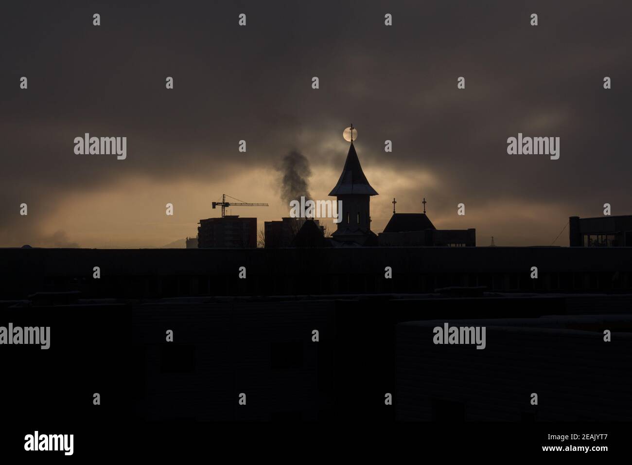 Lever du soleil avec brouillard et ciel sombre avec église silhouette et les bâtiments et le soleil derrière les bâtiments Banque D'Images
