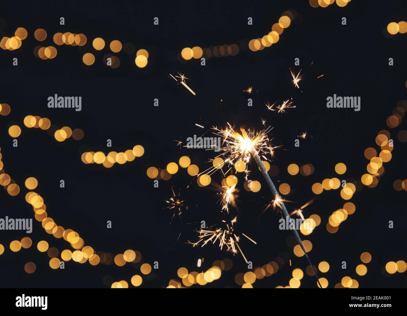 Sparkler brûlant avec fond de bokeh festif pour le nouvel an et le concept de Noël, espace pour le texte Banque D'Images