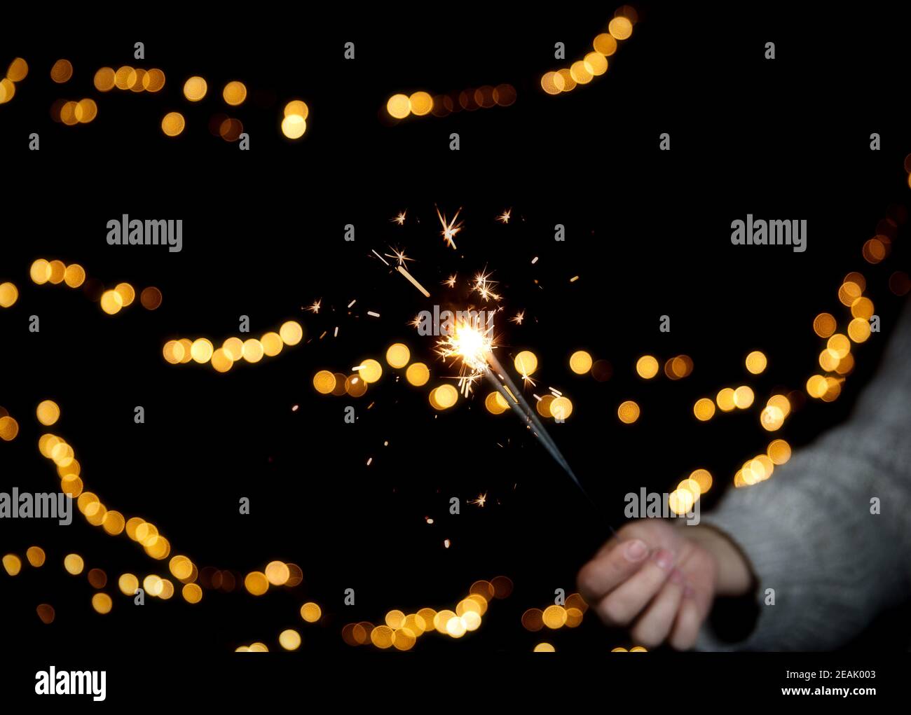 Sparkler brûlant avec fond de bokeh festif pour le nouvel an et le concept de Noël, espace pour le texte Banque D'Images