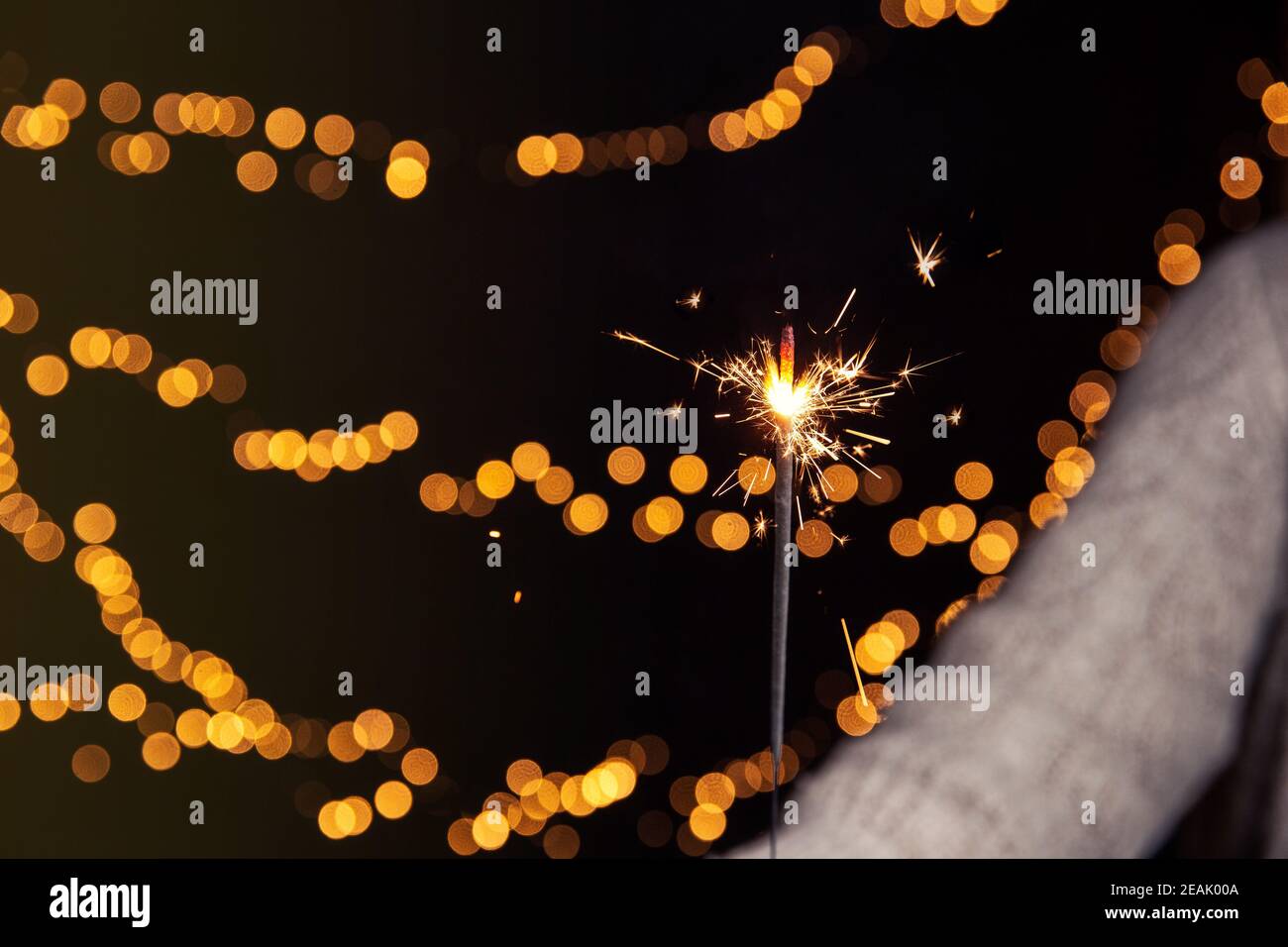 Sparkler brûlant avec fond de bokeh festif pour le nouvel an et le concept de Noël, espace pour le texte Banque D'Images