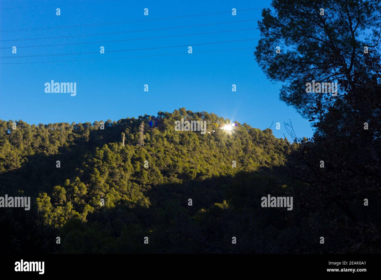 Reflet du soleil dans les fenêtres de certains bâtiments sur la montagne, créant une lumière blanche et très puissante qui surprend dans la montagne. Banque D'Images