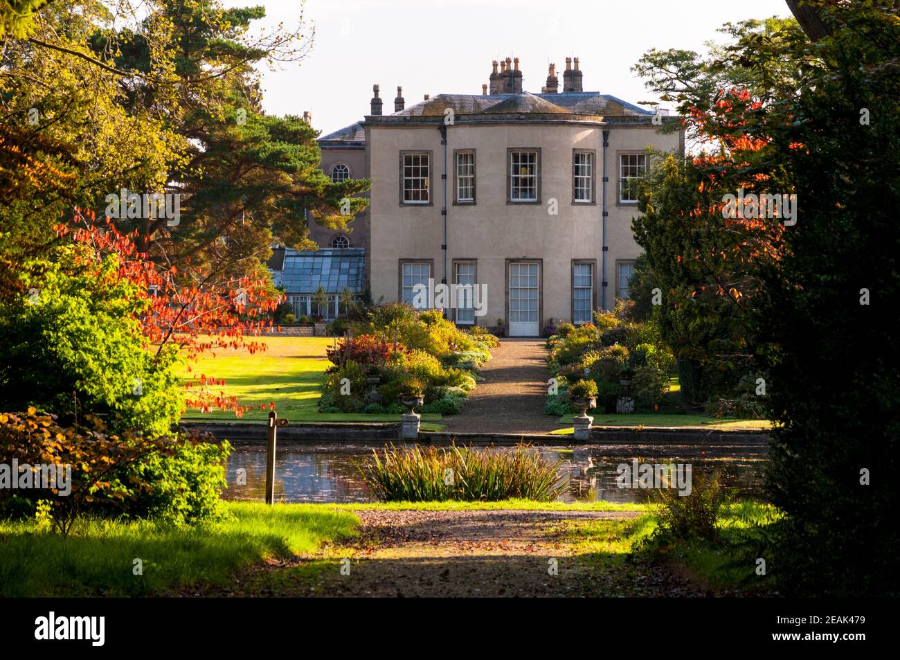 Vue sur Thorp Perrow Hall, une petite maison de campagne, vue sur un lac ornemental dans l'arboretum Thorp Perrow, dans le North Yorkshire. Septembre. Banque D'Images