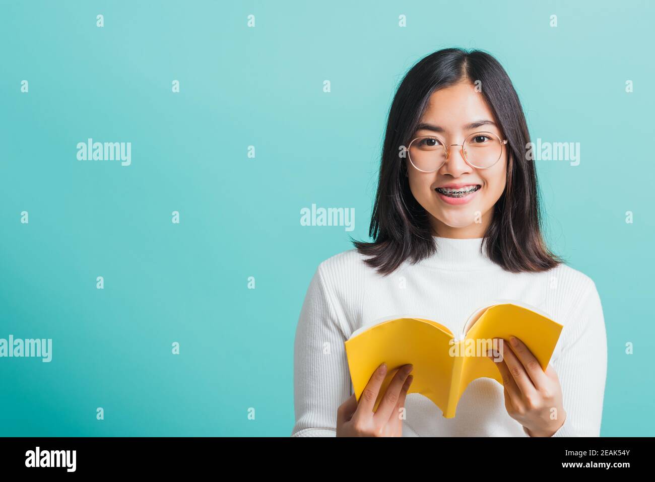 Portrait femelle en lunettes tient et lit un livre Banque D'Images