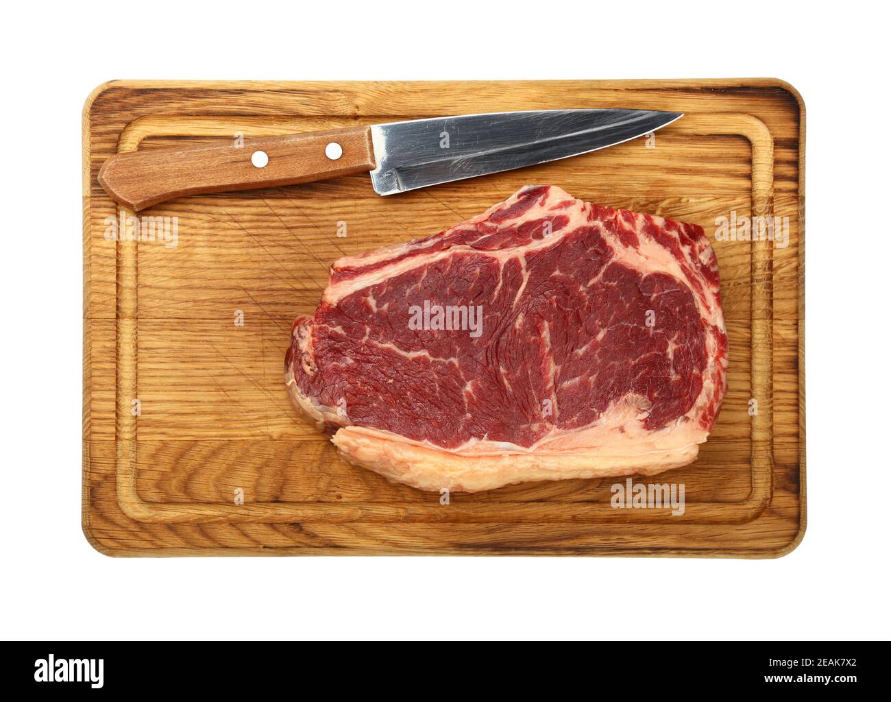 Gros plan sur un steak de bœuf cru à la ribeye sur une planche de bois Banque D'Images