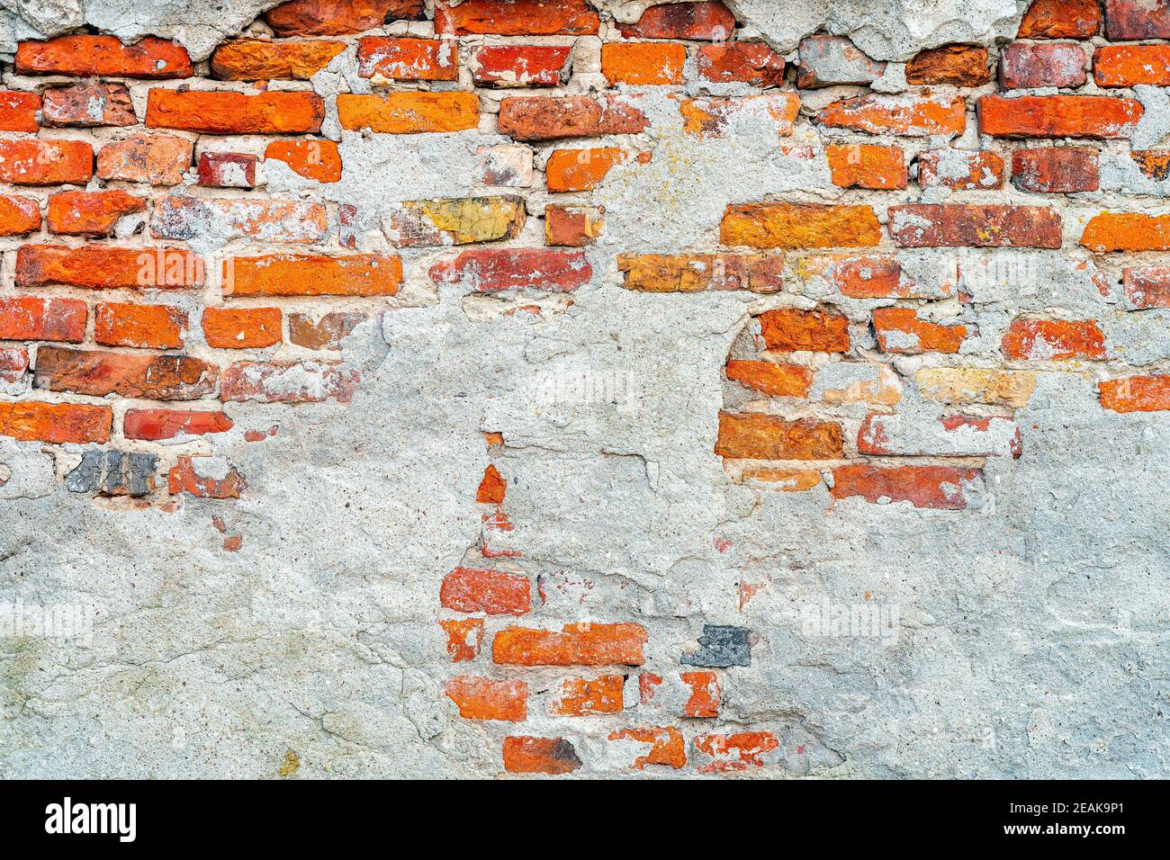 Vieux mur de briques rouge rustique corrodé et endommagé Banque D'Images