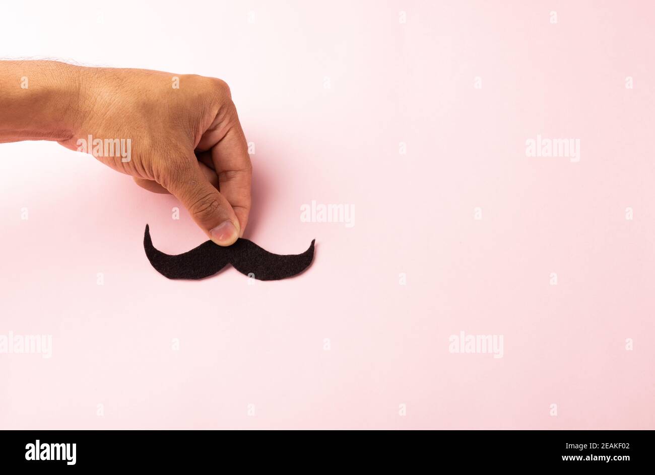 L'homme utilise la main tenant la moustache noire Banque D'Images