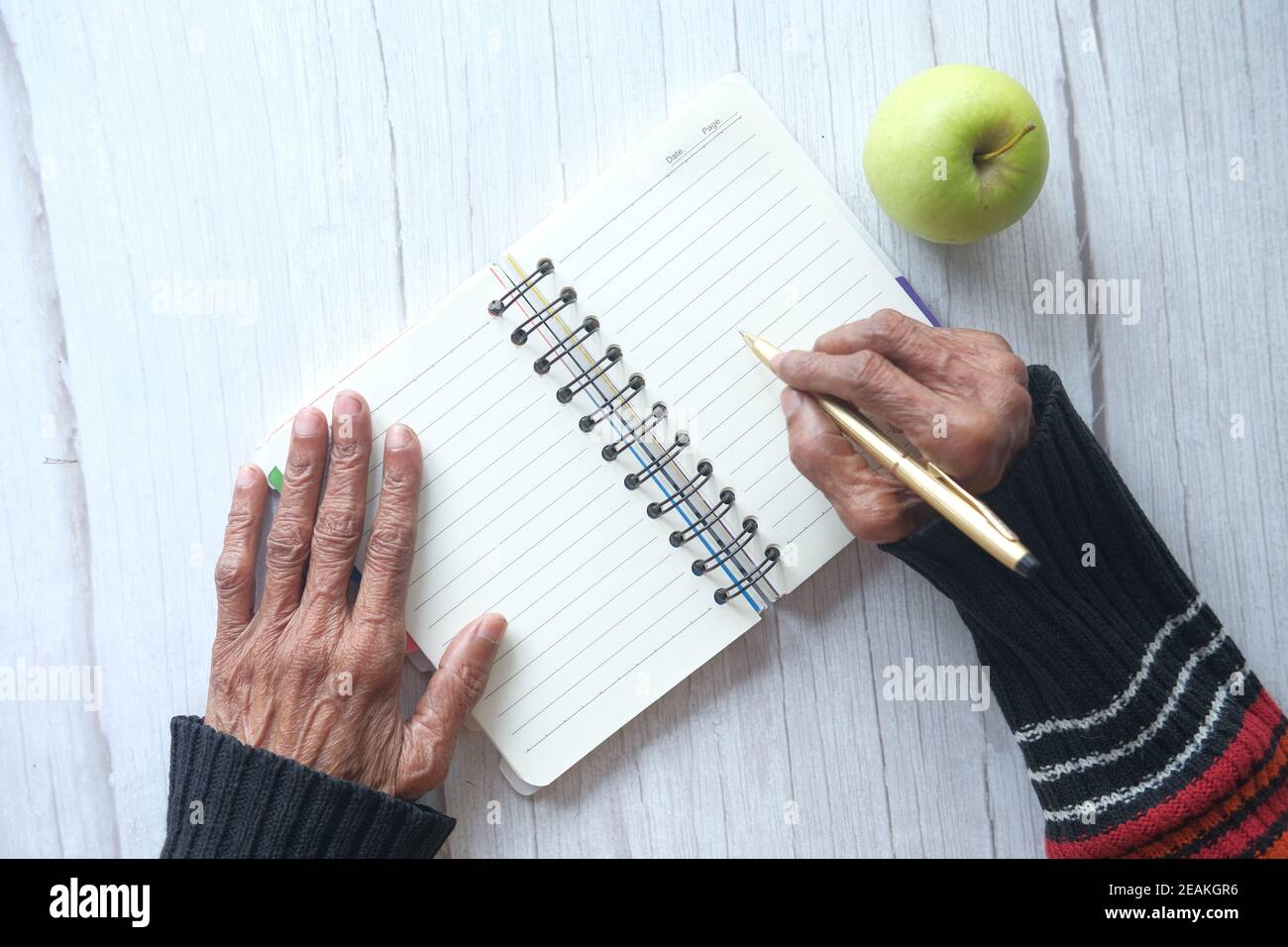 Gros plan sur l'écriture de main de femmes âgées sur le bloc-notes. Banque D'Images